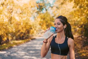 donna che fa attività fisica e beve acqua